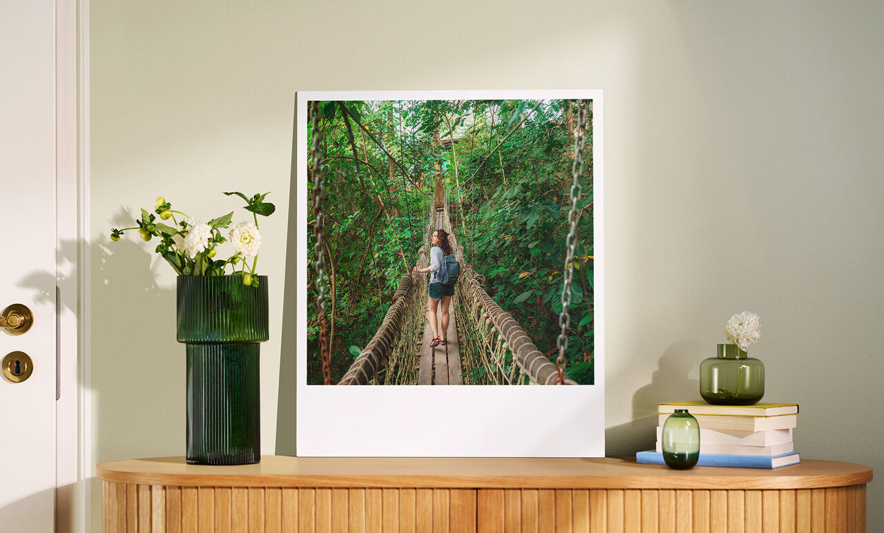 Two people enjoying a walk on a hanging bridge in a green forest.