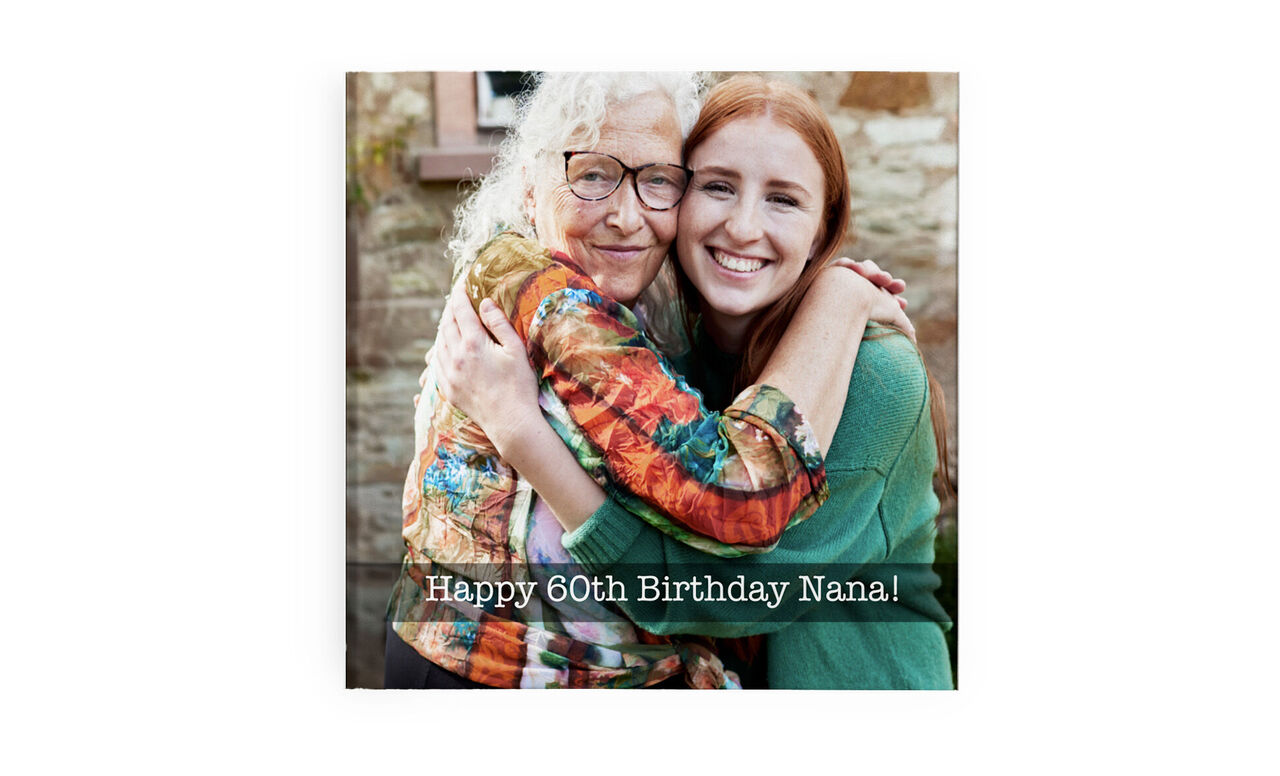 Two women warmly hug for a 60th birthday. A joyful celebration with a colorful motif.
