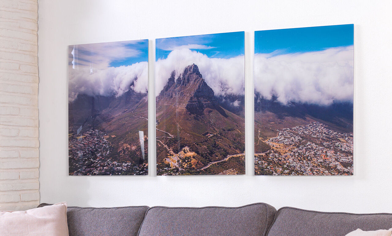 Three pictures of Table Mountain with clouds on a wall