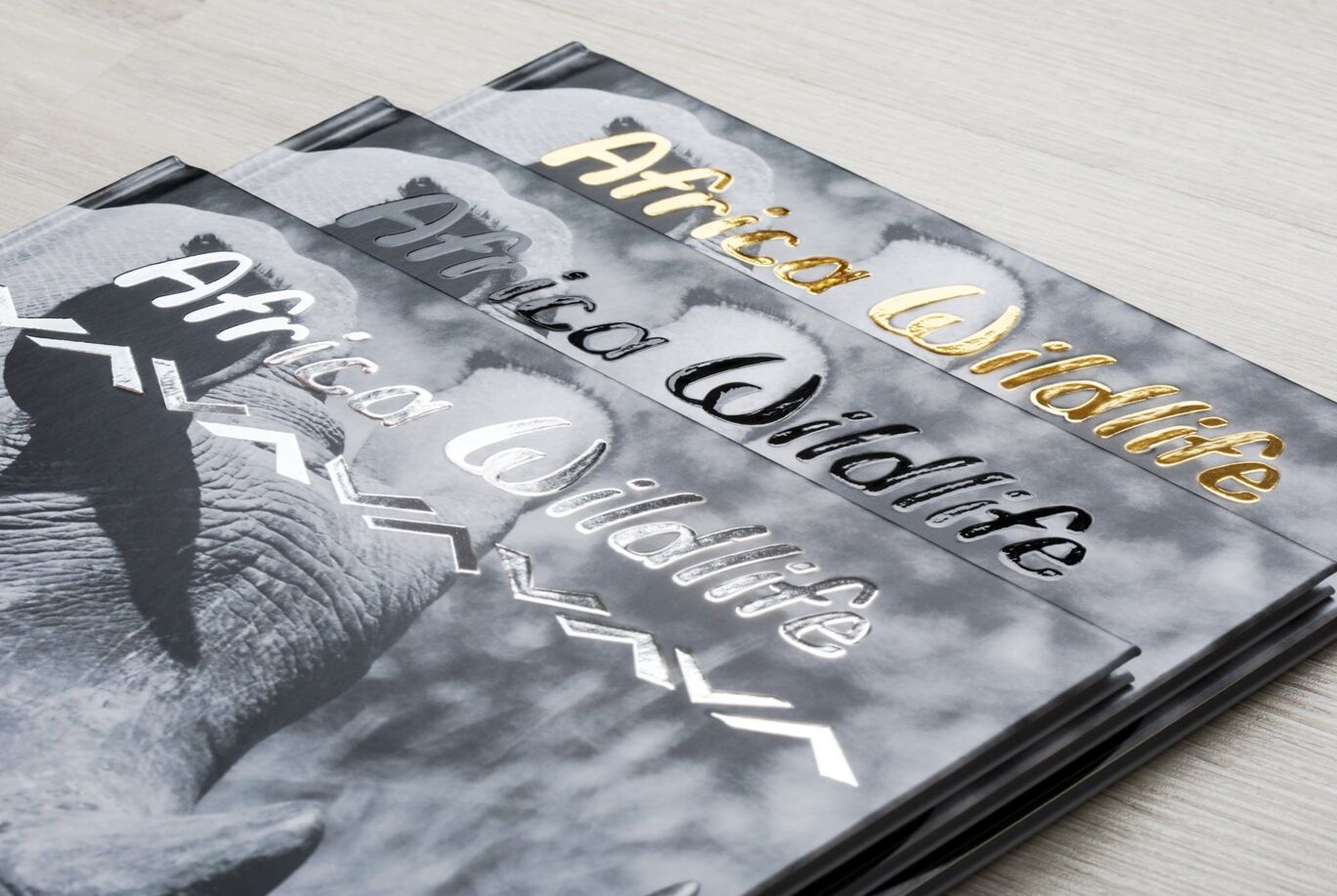 Three CEWE photo books titled 'Africa Wildlife' elegantly designed