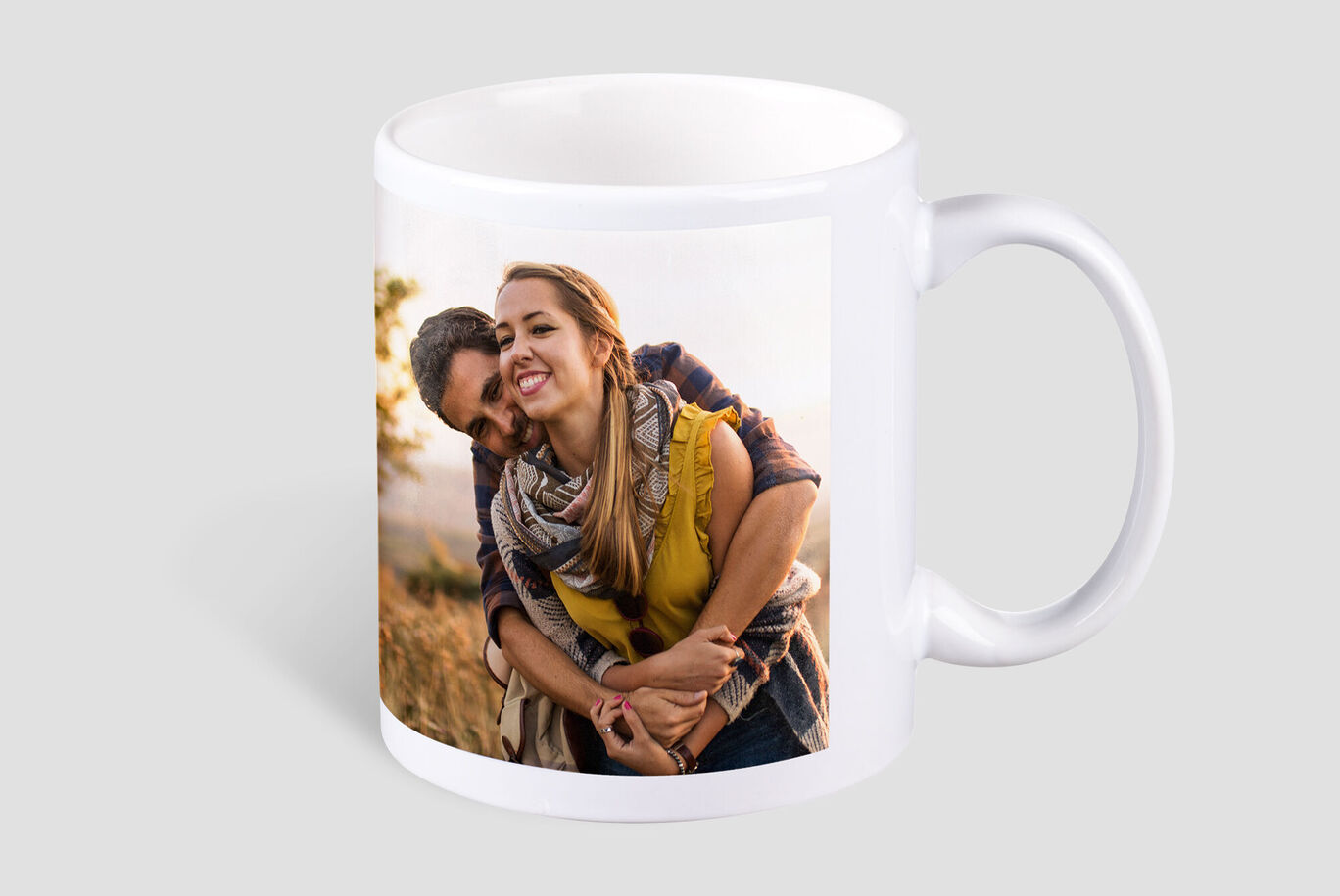 A smiling couple lovingly embraces in nature. They enjoy a happy moment together.