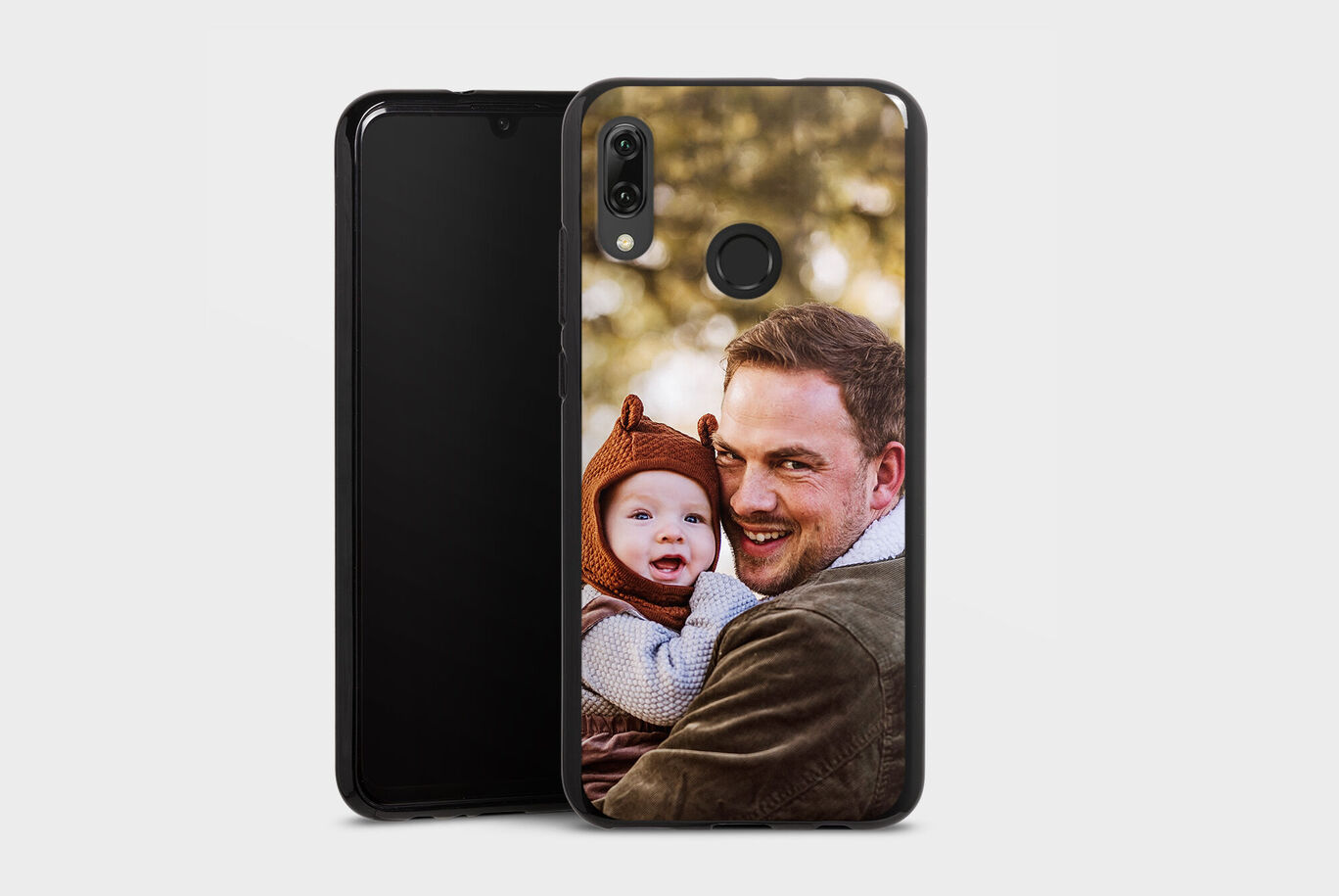 Young man hugs a toddler with a smile in a natural setting