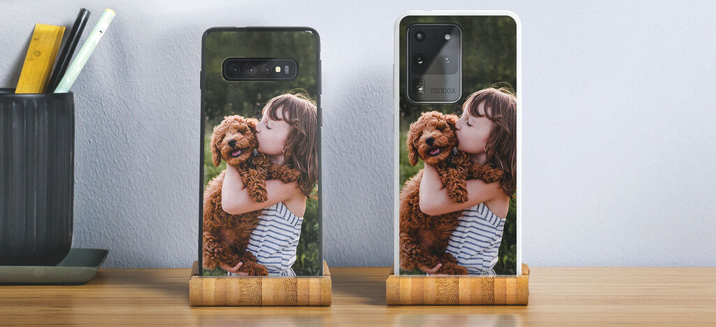 A girl in a striped shirt hugs a small brown dog and kisses it lovingly.