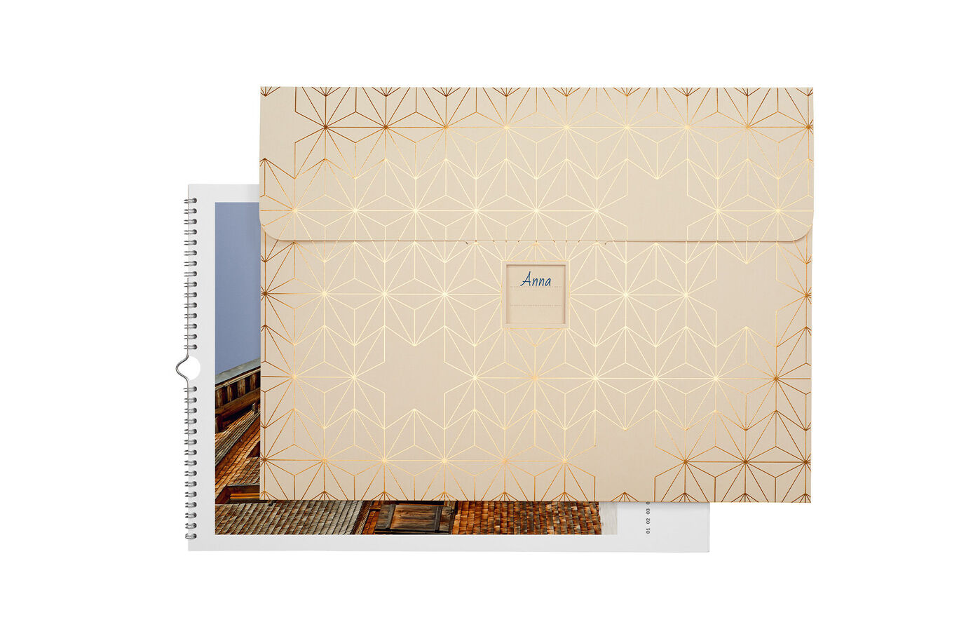 CEWE photo book with a golden geometric design and a personal name on the front.