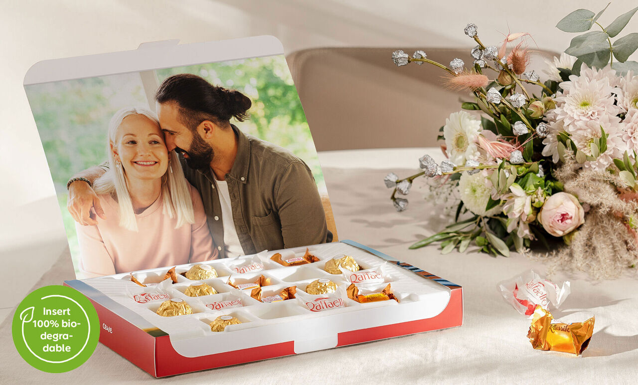 A lovingly wrapped gift with various snacks on a table, surrounded by flowers.