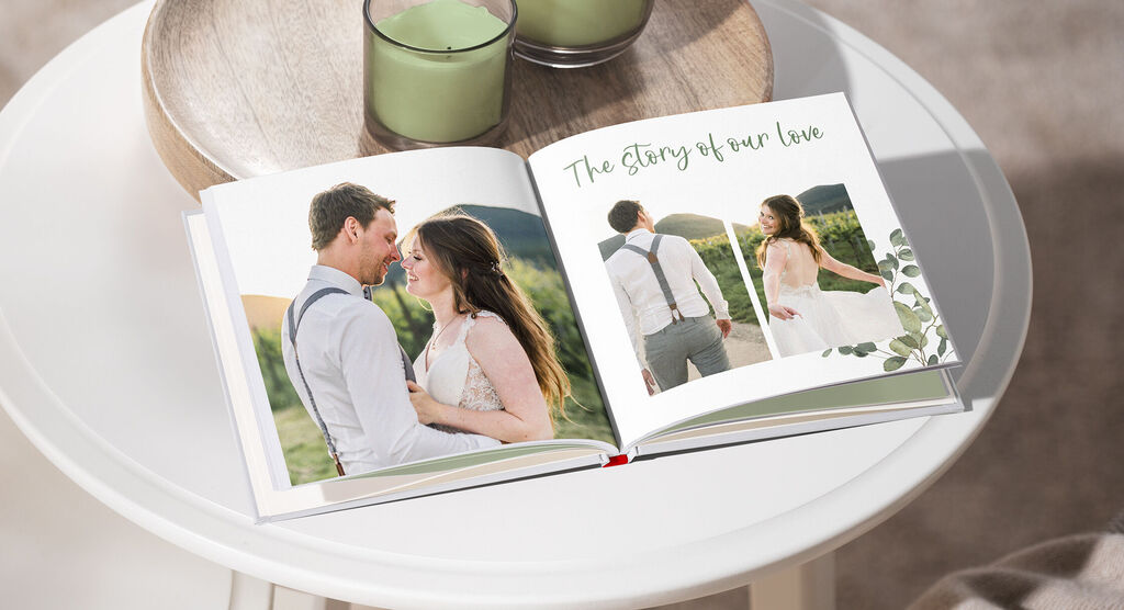 An open photo book with romantic pictures of a couple, surrounded by candles on a table