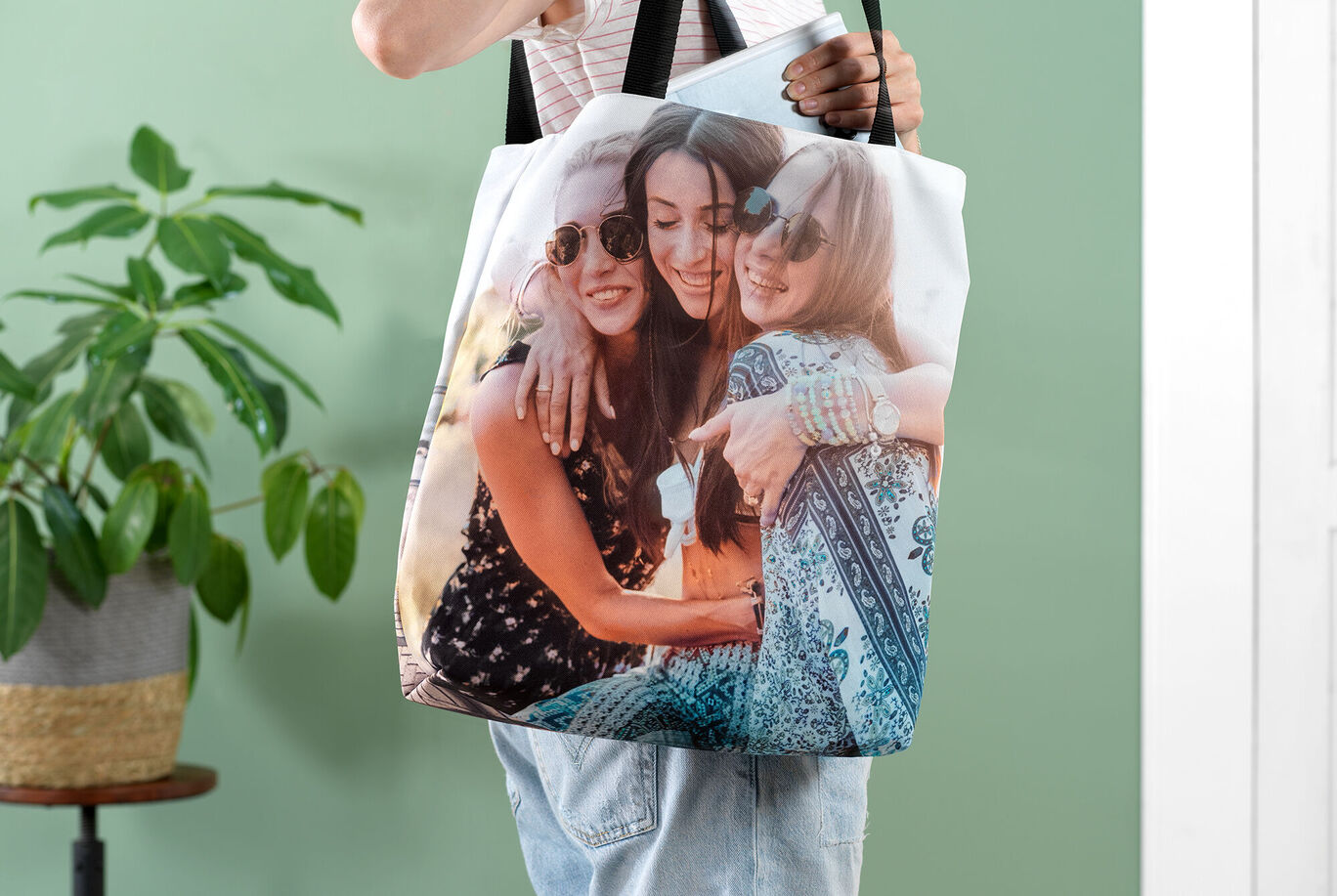 A person holding a cute bag with a photo print of friends. The bag shows a warm moment between two people in a friendly atmosphere.