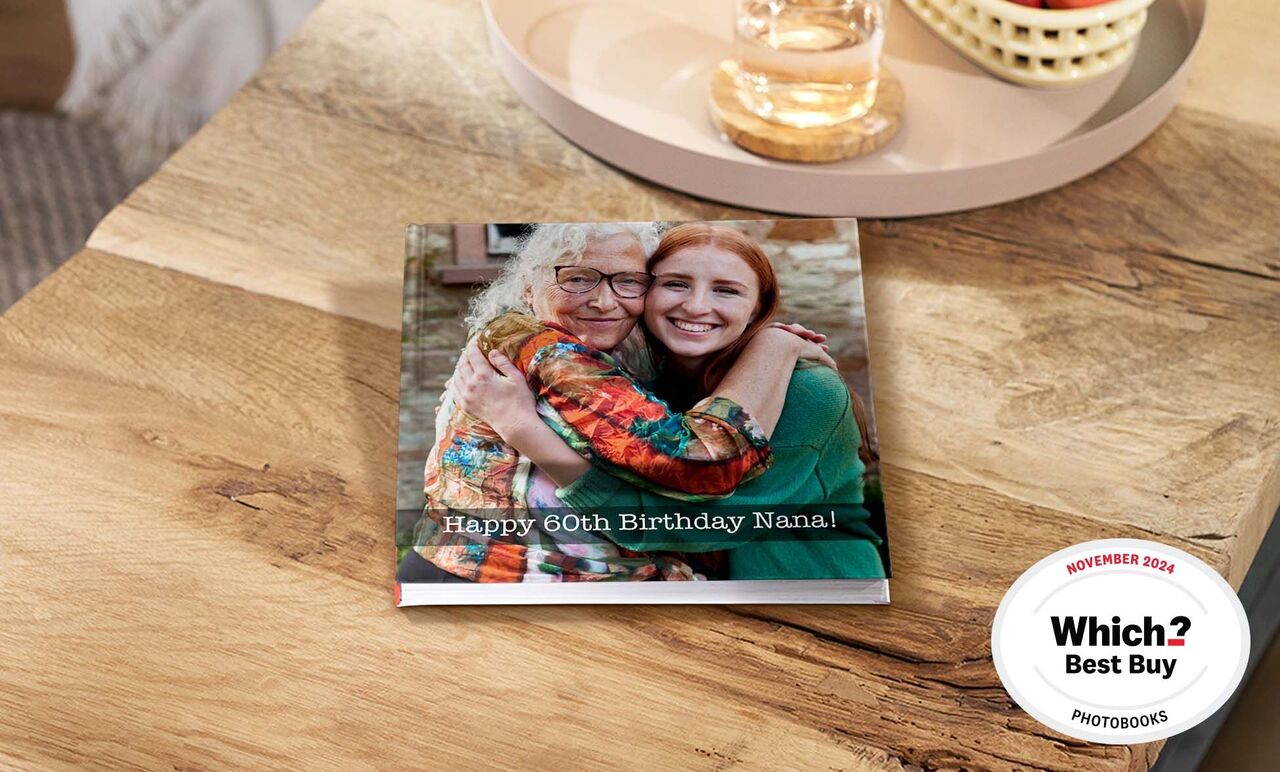 A lovingly designed photo book for Nana's 60th birthday on a wooden table.