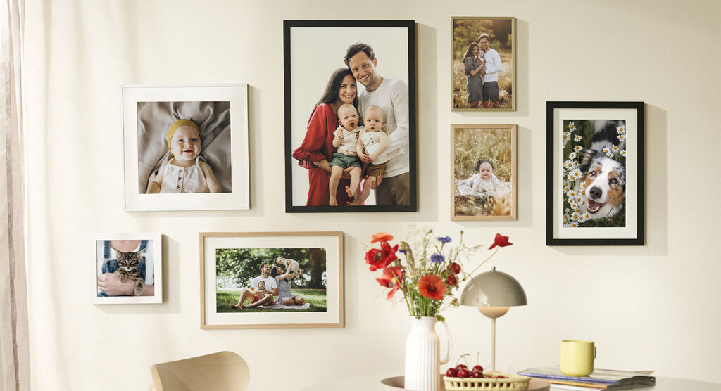 Colorful picture frames with family photos and a dog snapshot on a wall