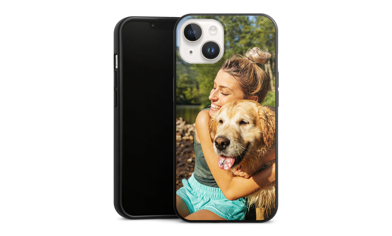 A person hugging a dog by the water.