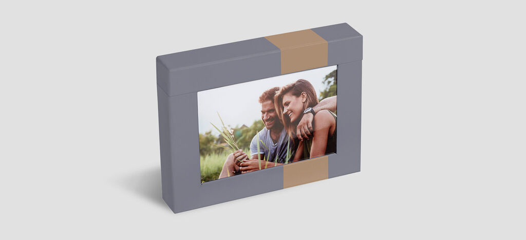 A lovingly designed picture frame with a snapshot of two smiling people enjoying a relaxed atmosphere.