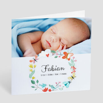 A lovingly designed birth announcement card with floral elements and space for photos.